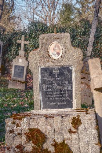 Mohutný kostel a rozlehlý hřbitov posetý německy psanými náhrobky dokazují, že v Újezdě Svatého Kříže žilo před druhou světovou válkou třikrát více obyvatel než v současnosti. | Die mächtige Kirche und der große Friedhof mit deutsch geschriebenen Grabsteinen deuten darauf hin, dass es in Heiligenkreuz vor dem Zweiten Weltkrieg dreimal so viele Einwohner wie heute gab.