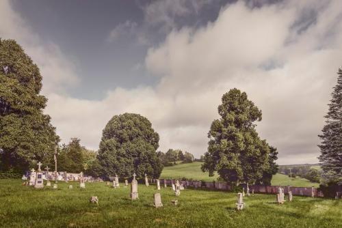 Mohutný kostel a rozlehlý hřbitov posetý německy psanými náhrobky dokazují, že v Újezdě Svatého Kříže žilo před druhou světovou válkou třikrát více obyvatel než v současnosti. | Die mächtige Kirche und der große Friedhof mit deutsch geschriebenen Grabsteinen deuten darauf hin, dass es in Heiligenkreuz vor dem Zweiten Weltkrieg dreimal so viele Einwohner wie heute gab.